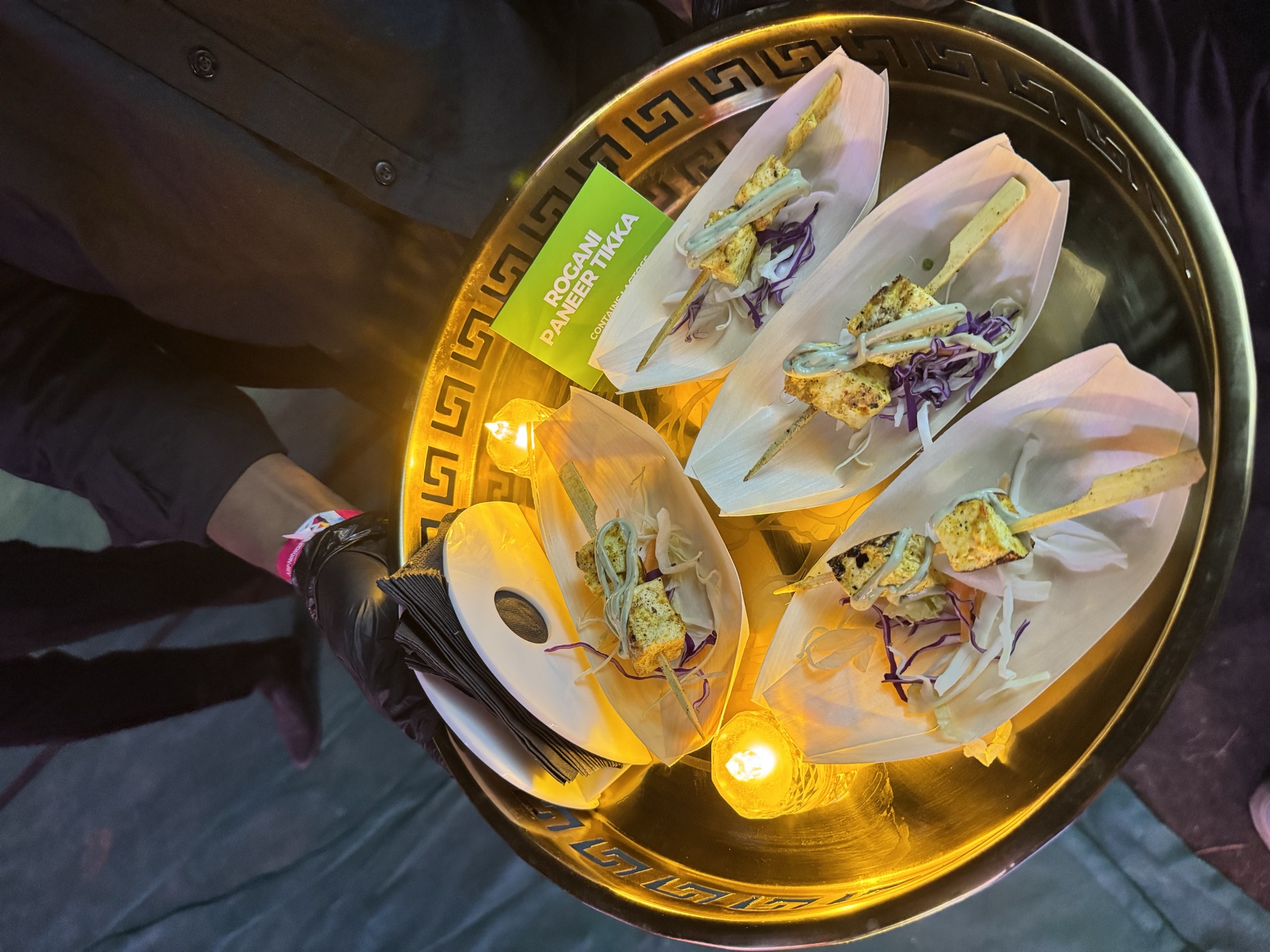 Service staff with gold tray of appetisers